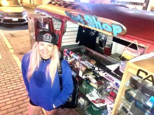 a woman standing in front of a food stand at Surf hostel My Friends in Huanchaco