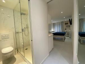 a bathroom with a shower and a toilet and a bedroom at Paris Canal Studio - Gare de l'Est in Paris