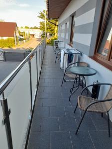 einen Balkon mit Tischen und Stühlen auf einem Gebäude in der Unterkunft Apartamenty U Elizy in Kołobrzeg