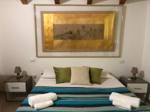 a bedroom with a bed with a painting on the wall at Cagliari Elmas Airport Beautiful Mansarda in Assemini