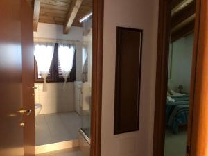 a door to a bathroom with a toilet and a room at Cagliari Elmas Airport Beautiful Mansarda in Assemini +31 photos