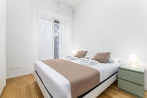 una camera bianca con un grande letto e una finestra di Casa da Suite Mirena a Milano