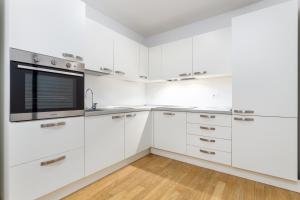 una cucina bianca con armadi bianchi e forno a microonde di Casa da Suite Mirena a Milano