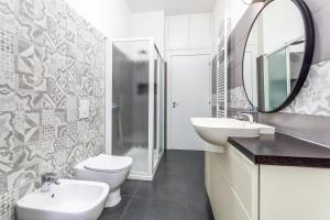 bagno con lavandino, servizi igienici e specchio di Casa da Suite Mirena a Milano