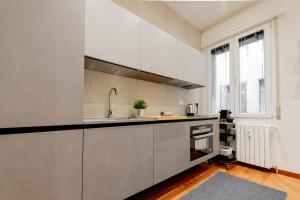 een keuken met witte kasten en een wastafel bij Realkasa Amendola Apartment in Bologna