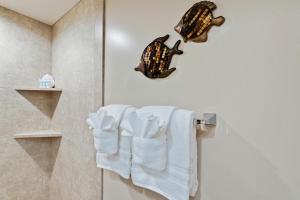 a bathroom with white towels and a towel rack at Maui Banyan H311 1BD 2BA 3 min walk to the beach in the Heart of South Kihei! in Wailea