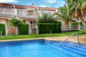 una piscina frente a una casa en ARENDA Pino Alto Holiday Home Cristal 9, en Miami Platja