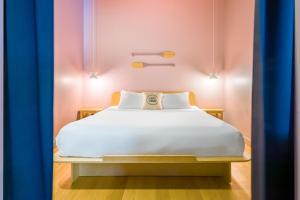 een bed in een kamer met roze en blauwe gordijnen bij Les Lofts de la Fabrique by Les Lofts Vieux-Québec in Québec
