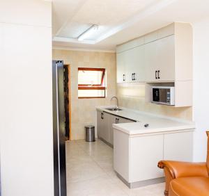 a kitchen with white cabinets and a sink at Gukurume- Gaborone in Gaborone