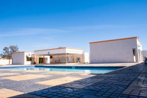 a house with a swimming pool in front of a building at Gukurume- Gaborone in Gaborone