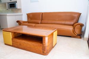 a brown leather couch sitting next to a coffee table at Gukurume- Gaborone in Gaborone