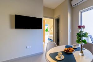 uma sala de estar com uma mesa e uma televisão na parede em Vakakis Family Luxury Studios 2 em Palaiochora