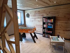 een kamer met een bed en een boekenplank bij Gîte 28 court in Bastenaken