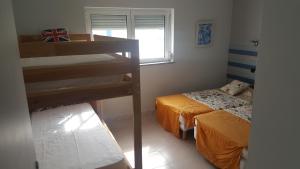 sypialnia z 2 łóżkami i łóżkiem piętrowym w obiekcie casa litoral w mieście Pataias