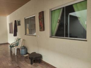 a room with two windows and a bench and a table at Recanto Aconchego in Rio Verde