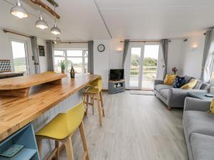 a kitchen and living room with a table and chairs at Porthwen Lodge in Amlwch