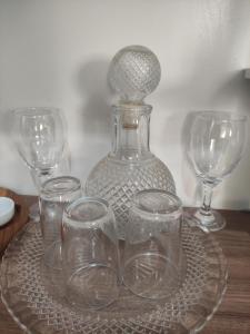 a glass plate with four glasses on a table at Recanto Aconchego in Rio Verde