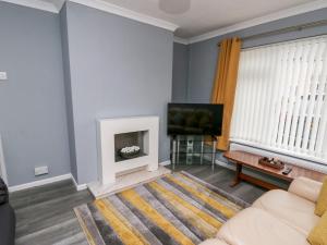 uma sala de estar com um sofá e uma televisão em 11 Bro Celyn em Holyhead