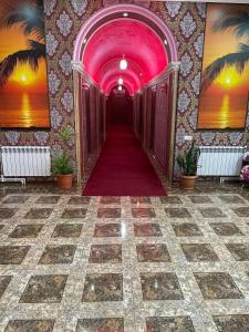 einen Flur mit einer rosa Decke und einem roten Teppich in der Unterkunft Zangezur Hotel in Goris