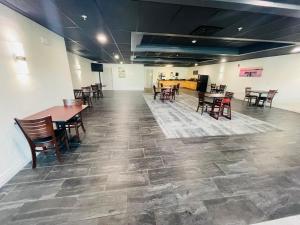 a room with tables and chairs and a floor with tiles at FairBridge Inn & Suites Cuero in Cuero