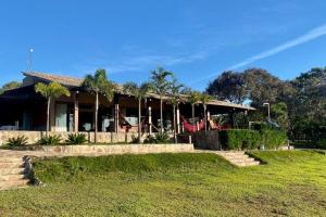 a house with a grassy yard in front of it at Sítio São Chico in Alto Paraíso de Goiás