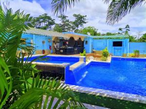 a blue house with a swimming pool at Mont Bleu Hôtel in Assougoula Emo