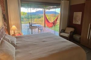 a bedroom with a bed and a view of a patio at Sítio São Chico in Alto Paraíso de Goiás +50 photos