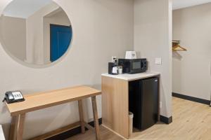 a room with a mirror and a table with a microwave at Days Inn by Wyndham San Diego-East/El Cajon in El Cajon