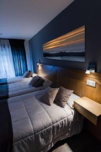 1 dormitorio con 2 camas y un cuadro en la pared en Hostal Libertad, en Gijón