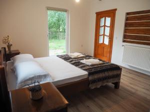 a bedroom with a bed with a table and a window at Wild-Traditional Bucovina in Câmpulung Moldovenesc