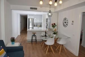 Il comprend une cuisine et un salon avec une table et des chaises. dans l'établissement Spectacular Apartment 8 pax/4 rooms & Free Parking, à Malaga