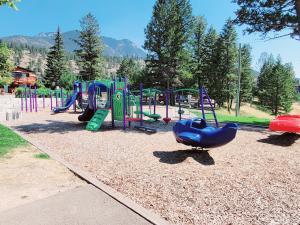 um parque infantil com um escorrega azul num parque em Mountain Springs Motel em Radium Hot Springs