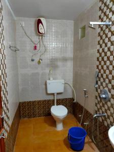 a small bathroom with a toilet and a shower at Kanikasundari Home Stay in Bālianta