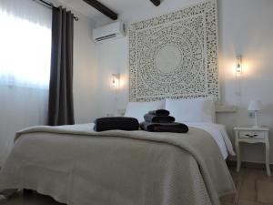 a white bedroom with a bed with towels on it at Onar Luxury Villa - Adults Only in Lachania