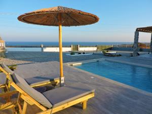 a chair with an umbrella next to a swimming pool at Onar Luxury Villa - Adults Only in Lachania