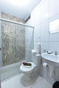 a bathroom with a toilet and a sink and a shower at Pousada Aconchego do Maraca in Porto De Galinhas