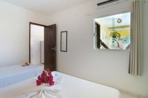 a white room with two beds and a mirror at Pousada Aconchego do Maraca in Porto De Galinhas