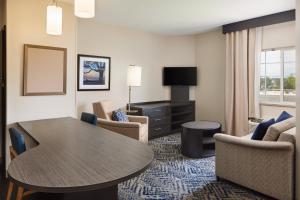 ein Wohnzimmer mit einem Tisch und Stühlen in einem Hotelzimmer in der Unterkunft Candlewood Suites Charleston-Northwoods, an IHG Hotel in Charleston