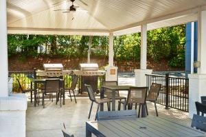 un patio extérieur avec des tables et des chaises ainsi qu'un toit dans l'établissement Candlewood Suites Charleston-Northwoods, an IHG Hotel, à Charleston