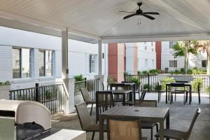 eine Terrasse mit Tischen und Stühlen und einem Deckenventilator in der Unterkunft Candlewood Suites Charleston-Northwoods, an IHG Hotel in Charleston