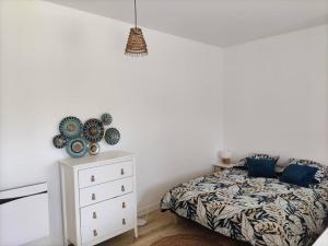 una camera con un letto e una cassettiera bianca con un letto di una piazza di Studio entre lac de Monteynard et Gresse-en-Vercors a Monestier-de-Clermont