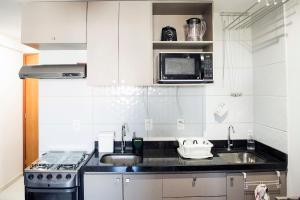 a small kitchen with a sink and a microwave at Studio Beira Mar - Sem Taxas in Recife
