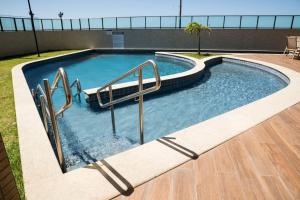 a swimming pool with stairs in a building at Studio Beira Mar - Sem Taxas in Recife