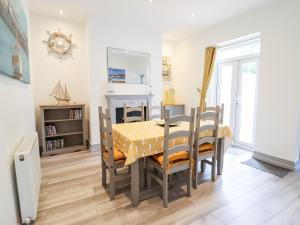 uma sala de jantar com uma mesa e cadeiras num quarto em Owen Villa em Llandudno