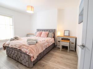 ein Schlafzimmer mit einem großen Bett und einem Schreibtisch in der Unterkunft Owen Villa in Llandudno