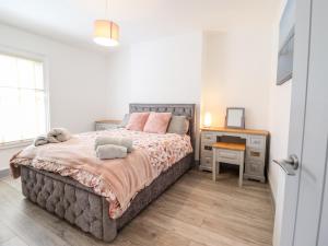 Un dormitorio con una cama grande y un escritorio. en Owen Villa, en Llandudno
