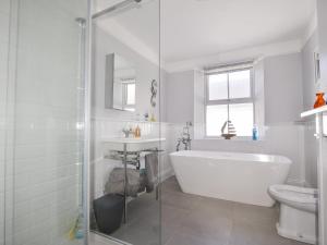 a white bathroom with a tub and a sink at 55 Queen Street in Seaton