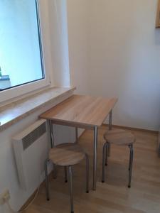 a wooden table and two stools next to a window at gemütliche kleine Ferienwohnung in Chemnitz