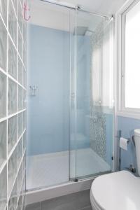 La salle de bains est pourvue d'une douche en verre et de toilettes. dans l'établissement FANTÁSTICO APARTAMENTO MADRID RIÓ-PUERTA DEL ÁNGEL, à Madrid