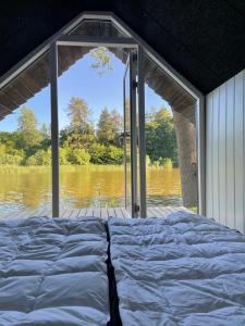 1 cama en una casa con vistas al río en Hyggelig sommerhus. med udsigt, til vand fra senge en Veksø